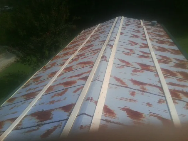 Rusted metal roof panels with new wood purlins before replacement — Storm Damage Roof Repair in Saint Anne by Roofing Brothers