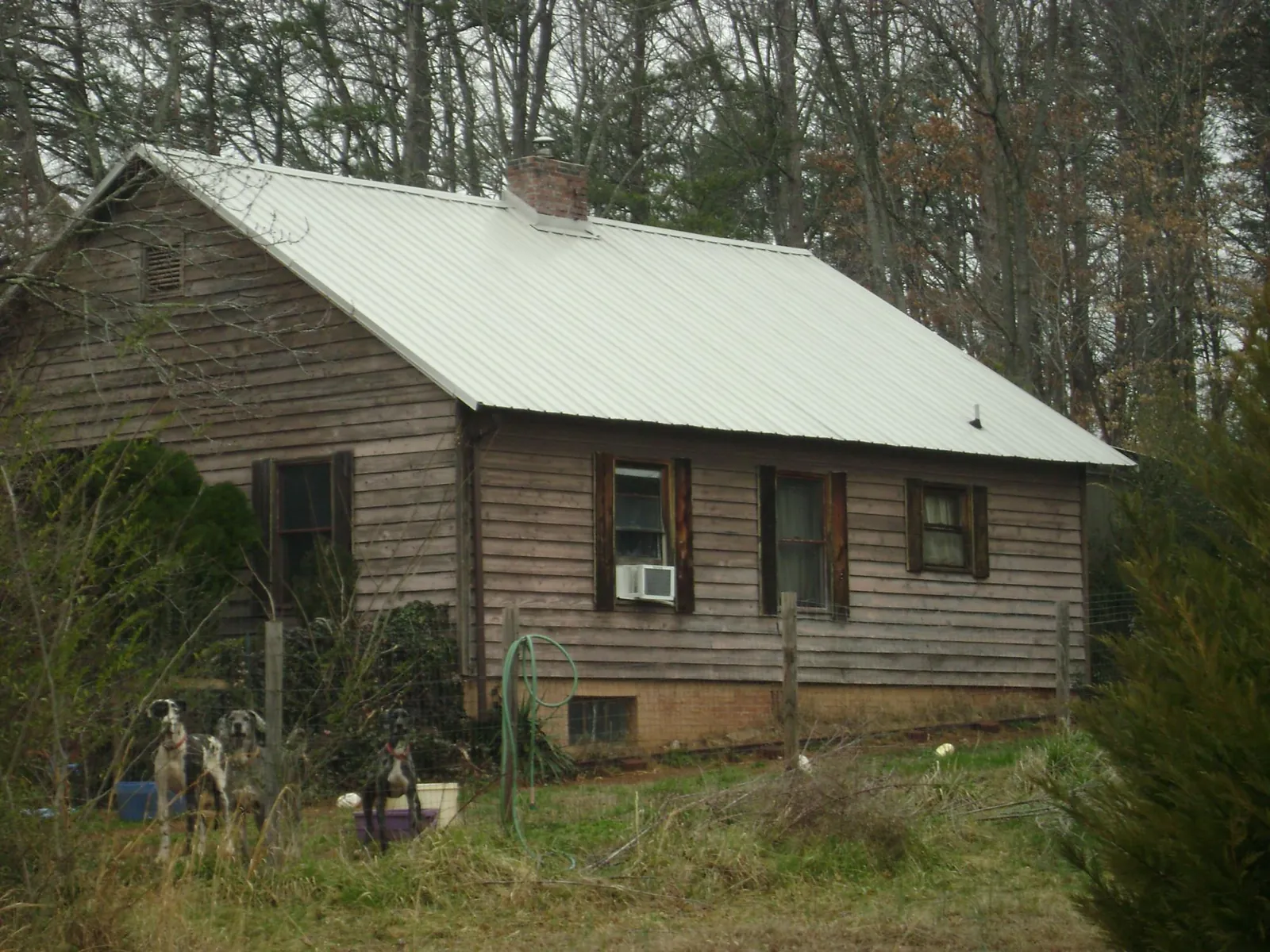 White metal roof on an old wood sided farmhouse, from a Metal Roof Installation job in Saint Anne